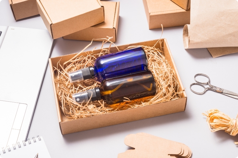 set-of-brown-and-blue-glass-spray-bottles-packed-in-cardboard-box-on-office-desk